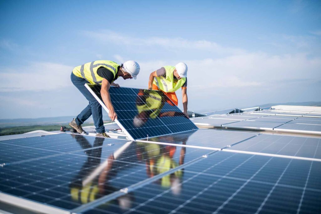 Techniker von ReGeTECH installieren Photovoltaik-Module auf einem Dach.